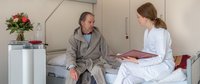 Ärztin im Gespräch mit Patient. 