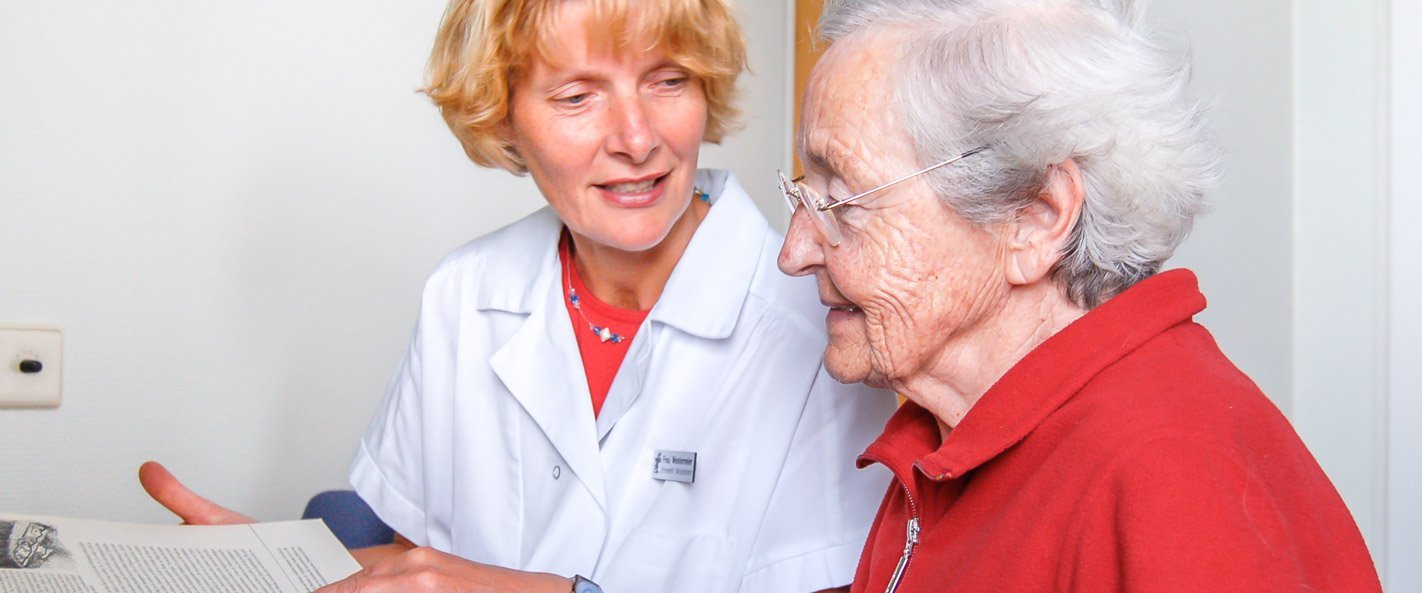 Ehrenamtliche Helferin im Austausch mit Patientin.