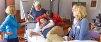 Pflegefachfrau lagert Pflegefachmann im Rahmen eines Weiterbildungsseminars.
